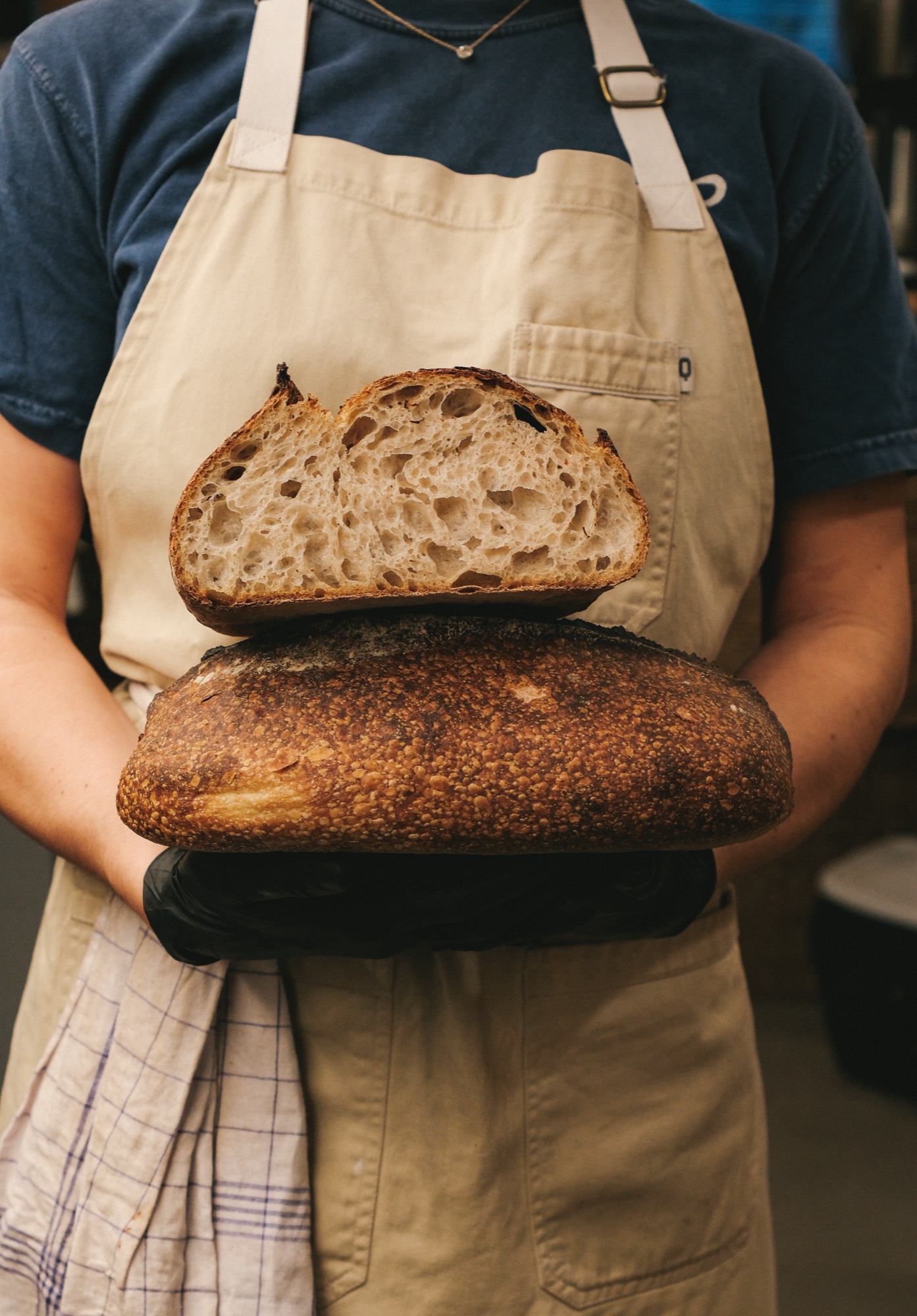 Baker holding sourdough loaf